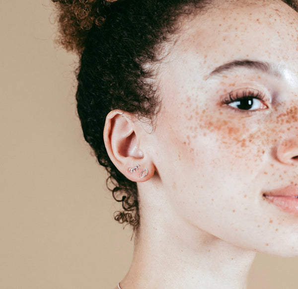 a closeup shot of our model wearing the silver open eyestuds